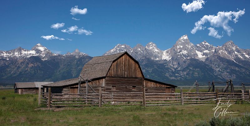 Weathered wooden barn beneath snow-capped mountains — western photography by Emily Coffeen
